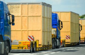 Comboio transportando carga superdimensionada por rodovia, representando a complexidade logística de um projeto especial.